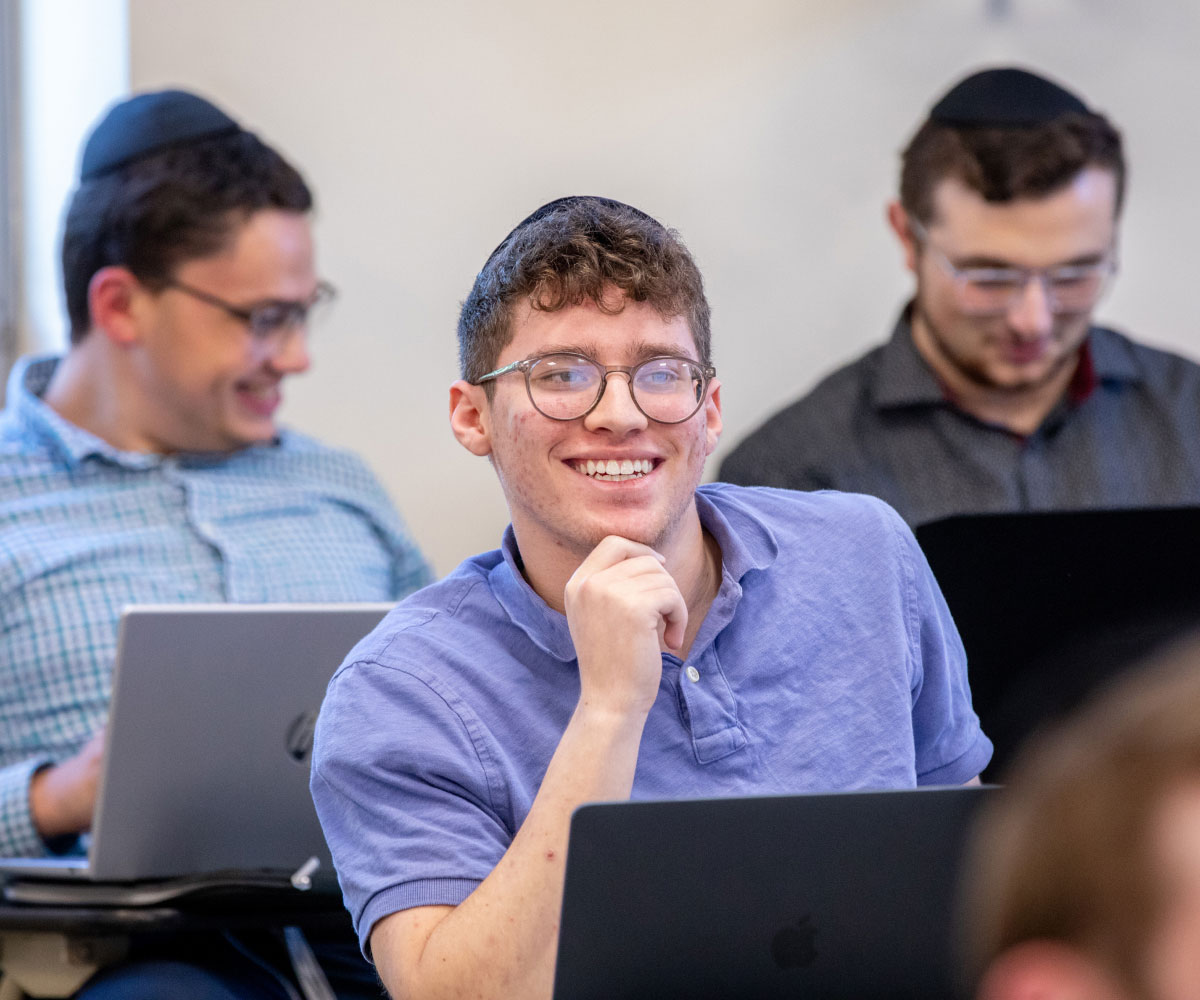 Student smiling at desk in classroom