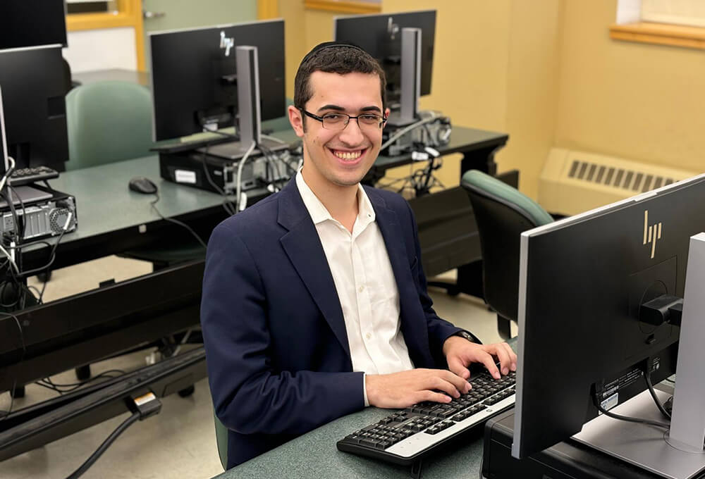 Avi Weiner sitting at a computer in a computer lab