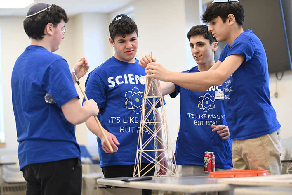 4 teenage boys working on project in Science Olympiad