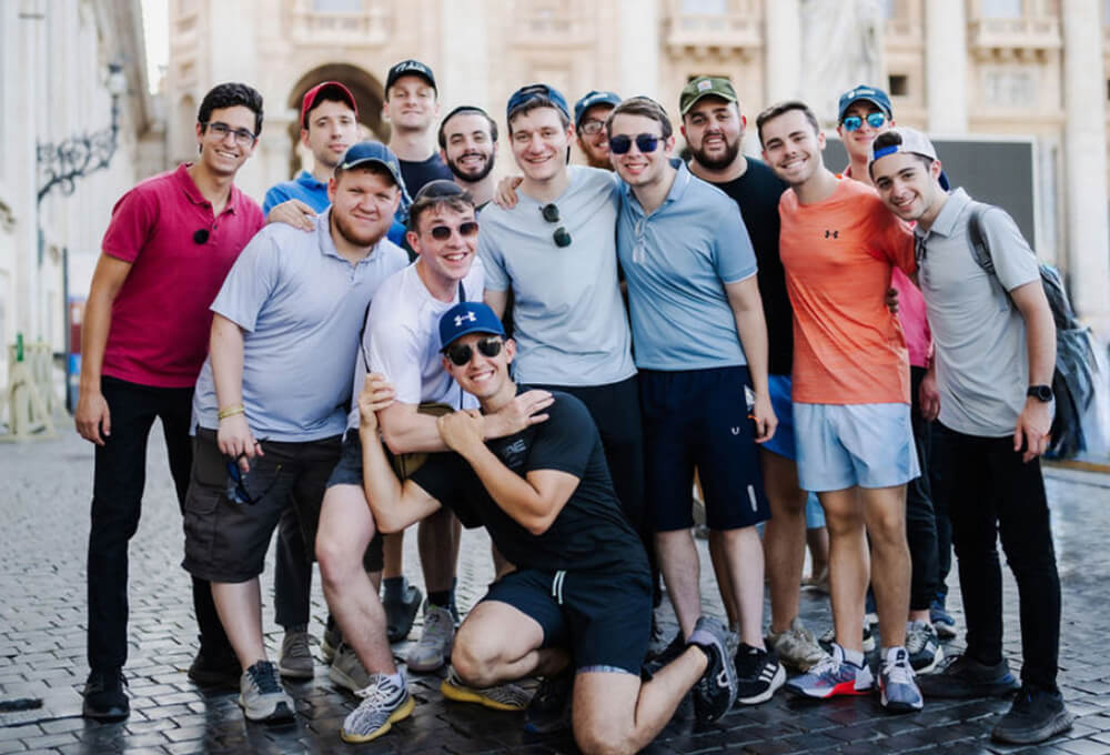 Students from Lander College of Men pose in a group, with historic buildings in the background