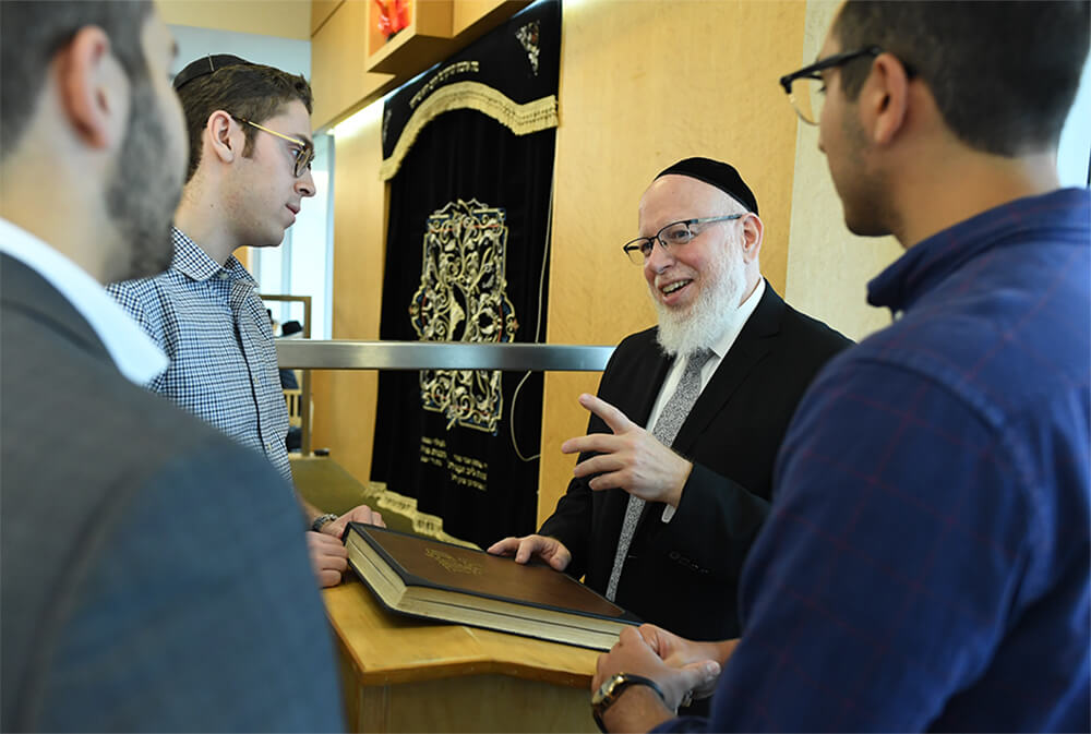 Rabbi Yonason Sacks with students in Jewish study hall
